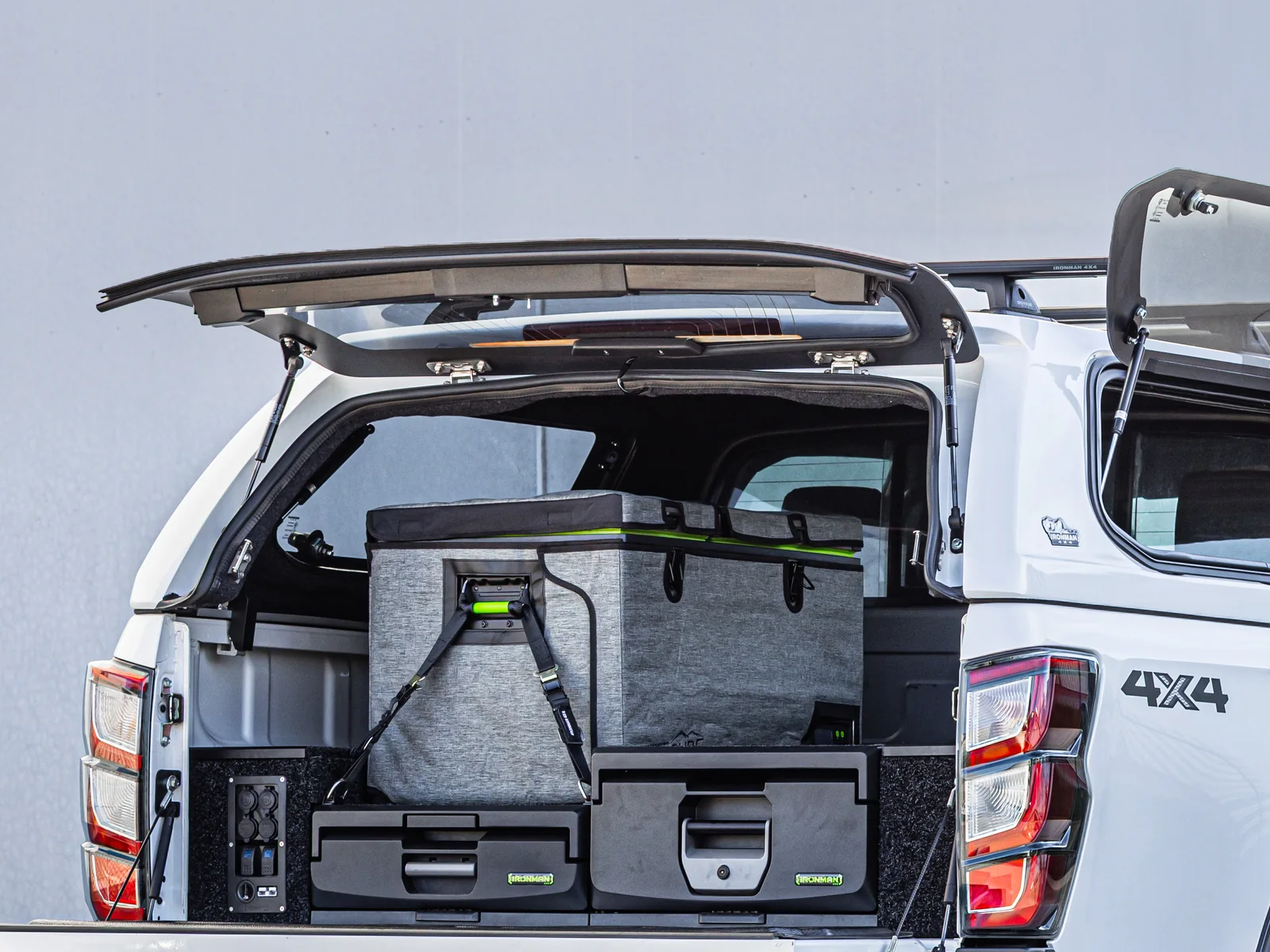 A fitted-out ute tub with an IRONMAN 4X4 drawer system, a fridge and power outlets under an open canopy