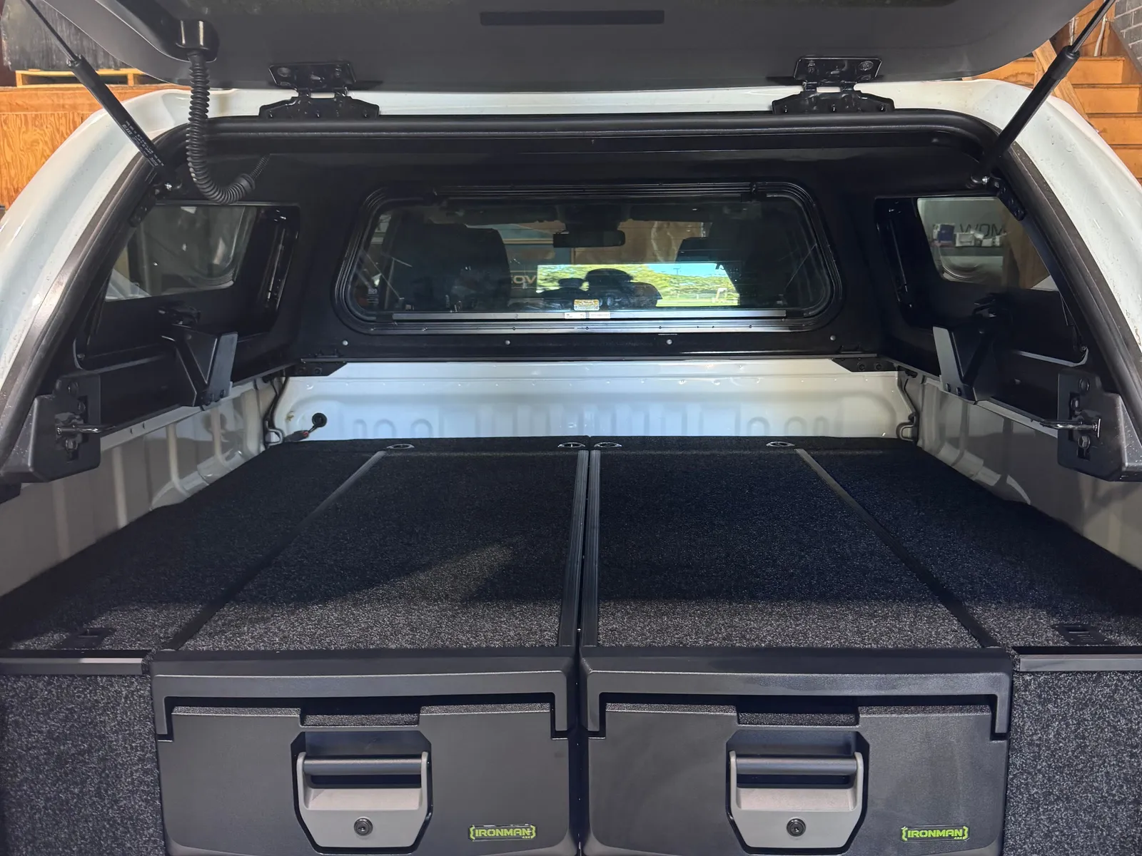 An IRONMAN 4X4 twin drawer system fitted in the tub of a white ute, under an open canopy