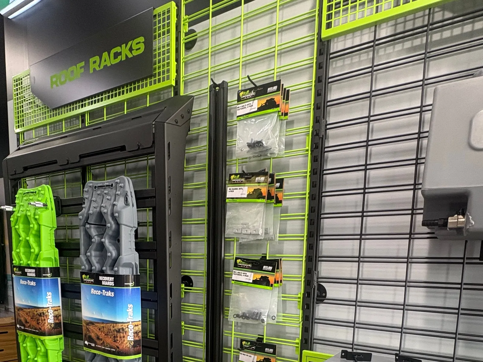 The roof racks wall in the IRONMAN 4X4 Wollongong showroom, with recovery boards, a roof platform and fitting kits on display