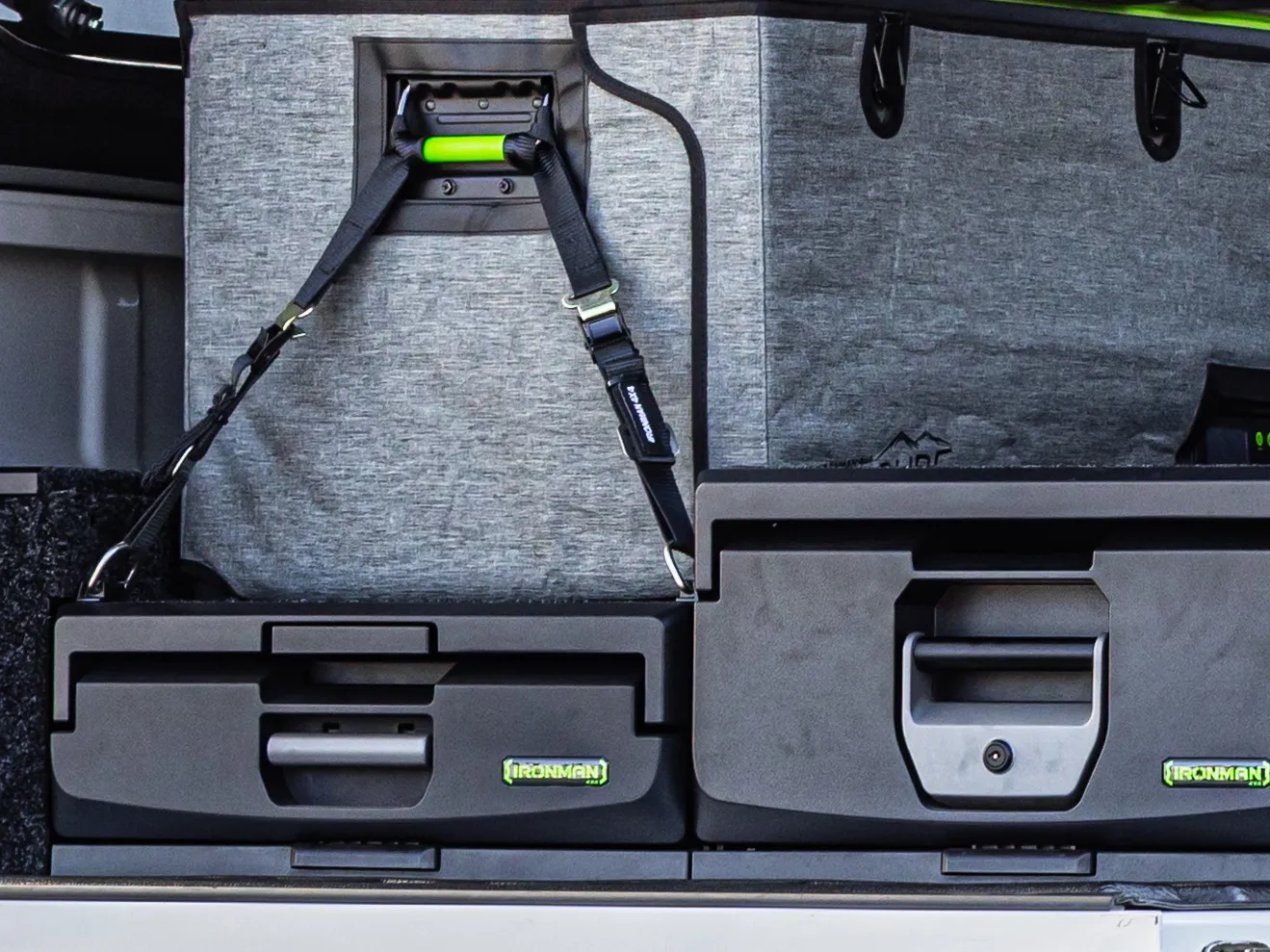 An IRONMAN 4X4 drawer system with a strapped fridge above it in the back of a ute canopy